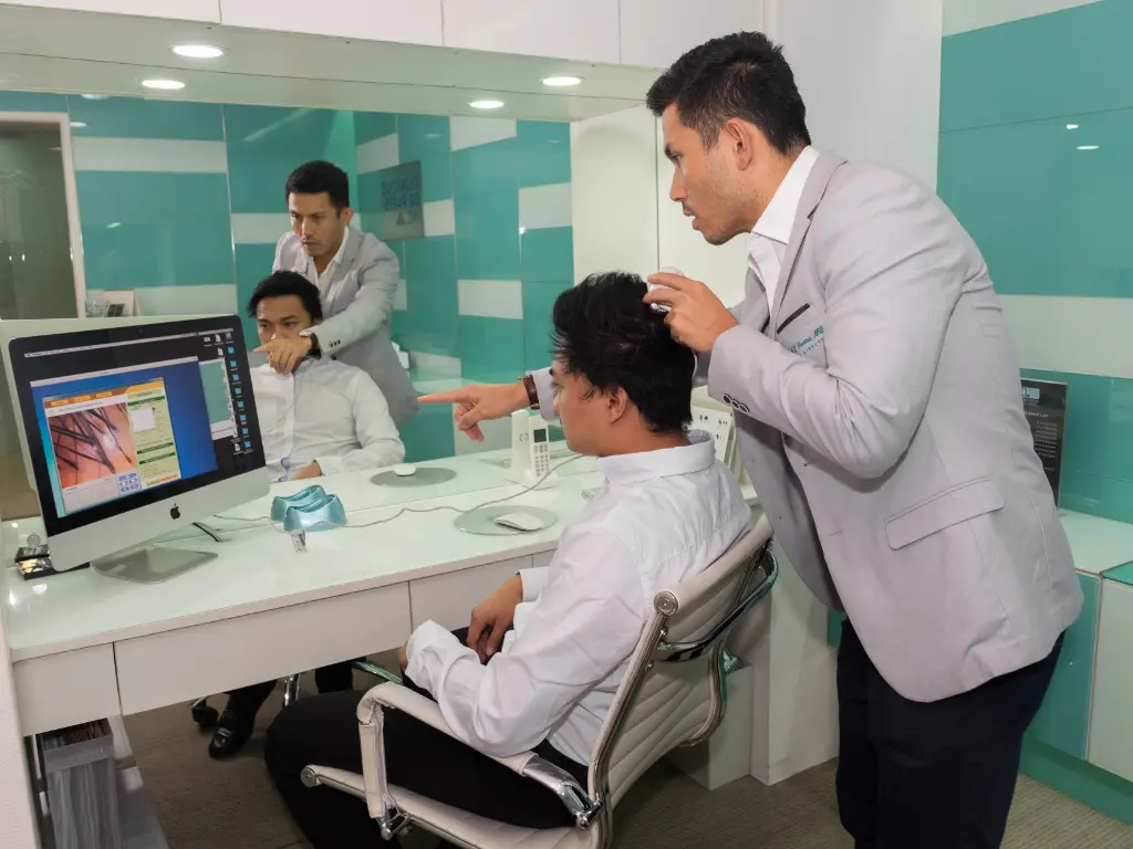 Medical doctor assessing hair and scalp for hair transplant at Clinique de Paris