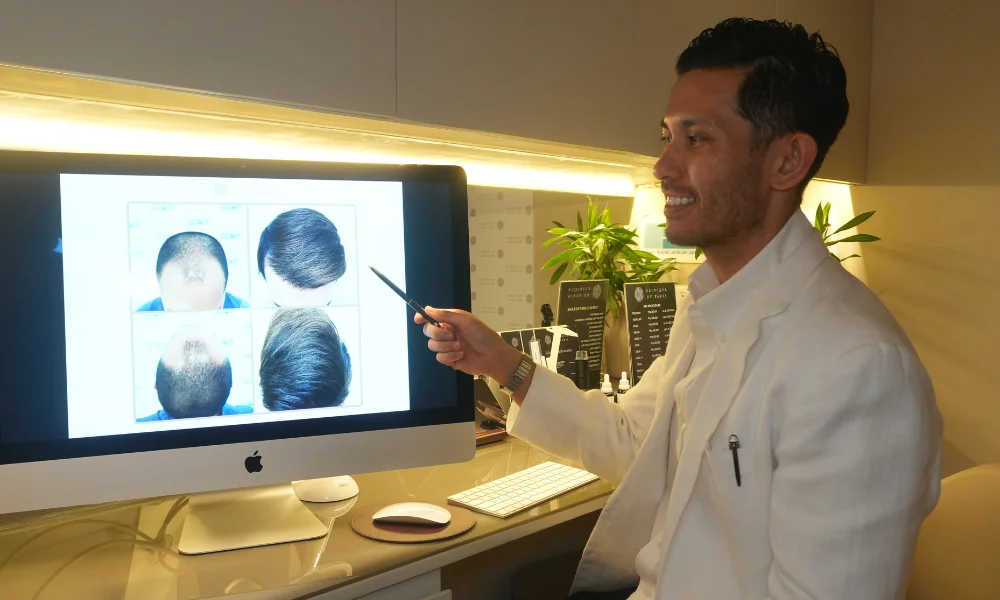 Doc Raf Fortus of Clinique de Paris pointing our the monitor showing stages of hair loss and restoration