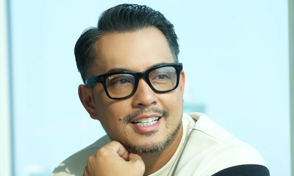 head shot photo of Jun Sunga with glasses wearing black and white stripes with his hand on this chin