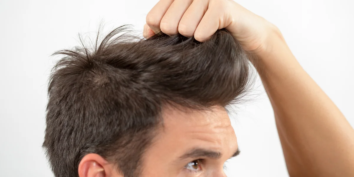man holding his hair styling